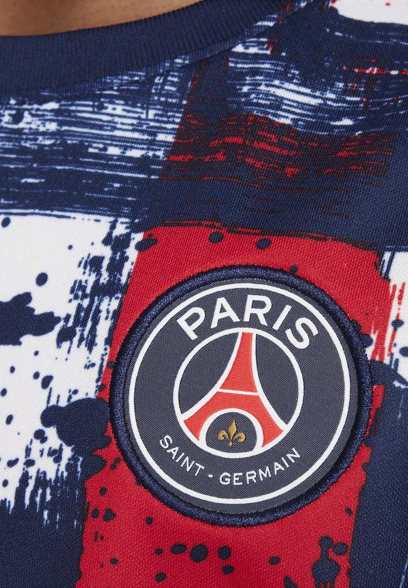 Das Kurzarmtrikot hat ein abstraktes Muster in Marineblau, Rot und Weiß. Es enthält ein rundes, gesticktes Patch mit dem Logo von "Paris Saint-Germain".