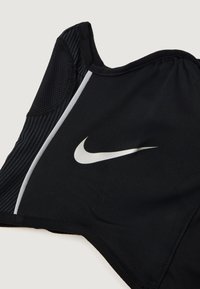 Čierny športový podprsenka s elegantným dizajnom, sieťovými detailami na ramene a reflexným logom Nike na prednej strane. Mäkký, elastický materiál.