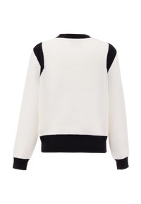 Maglione lavorato a maglia con una texture a costine, per lo più bianco con accenti neri sulle spalle, scollo rotondo e maniche lunghe.