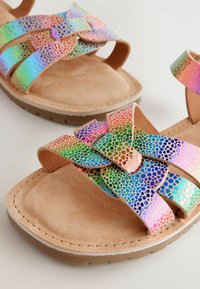 Multicolored sandals featuring iridescent, perforated straps and a suede footbed; flat design with a rubber sole and crossover detailing.