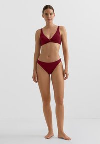 Bordo dvodelne bikini z zgornjim delom z V-izrezom in vozelom ter širokimi naramnicami ter nizko pristajočimi hlačkami, oba iz teksturirane rebraste tkanine.