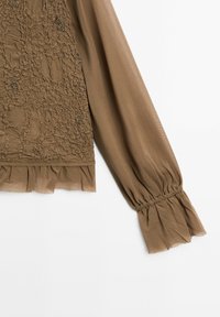 Blouse marron à manches longues avec devant texturé, tissu transparent et détails de volants aux poignets et à l'ourlet.