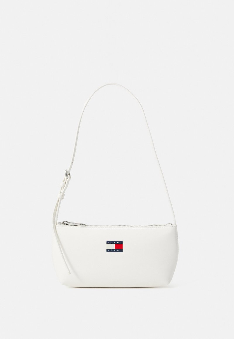 White leather shoulder bag with a curved shape, zip closure, and a small logo patch in blue, red, and white on the front.
