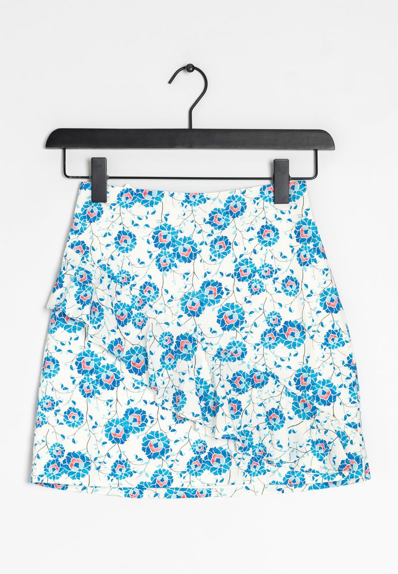 Jupe florale blanche, ornée de motifs de fleurs bleues et rouges. Conception à volants en plusieurs niveaux, fabriquée en tissu léger, avec un cintre noir.