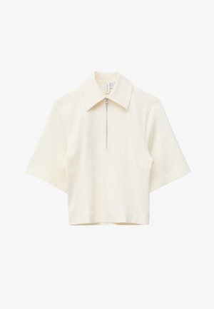Kremowa koszulka polo z krótkim rękawem, z srebrnym zamkiem błyskawicznym na połowie przodu i ostrym kołnierzykiem, prezentowana na białym tle.
