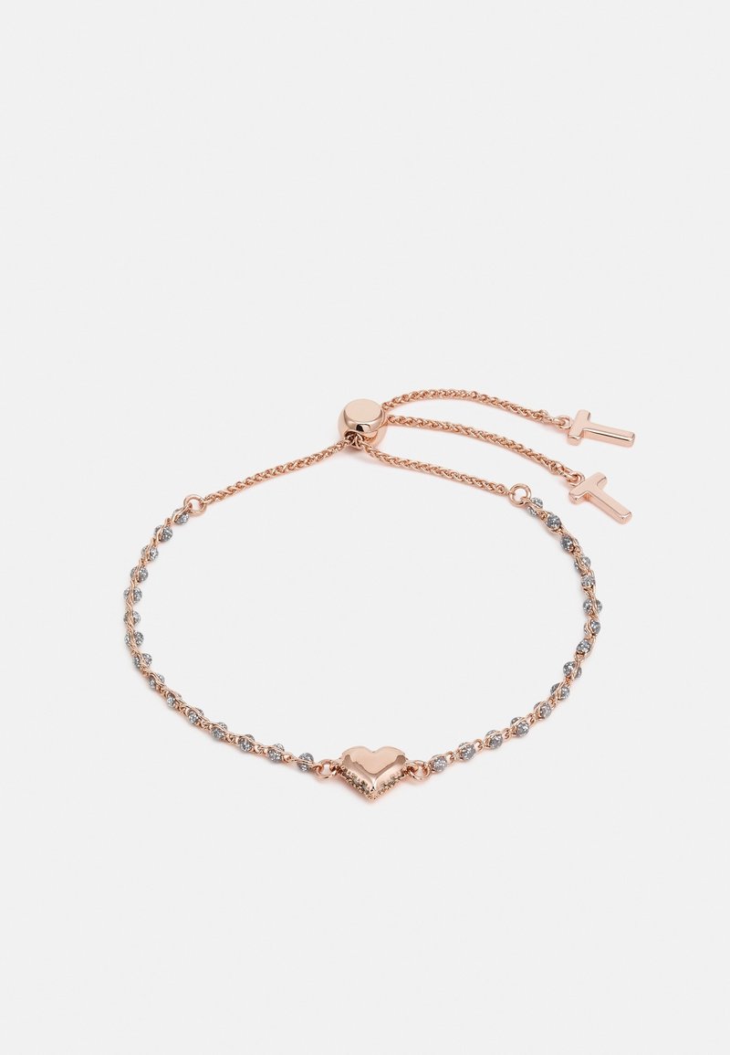Bracelet délicat ajustable en or rose avec un motif cœur au centre et de petites pierres claires incrustées le long des maillons de la chaîne.