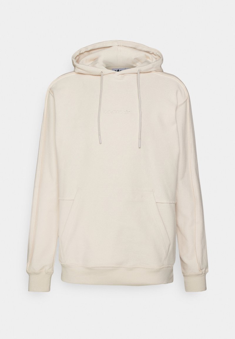 Krämfärgad hoodie med dragsko i huvan och framficka. Tillverkad av mjukt material med ribbade mudd och nederkant. Adidas-logotyp broderad i vitt.