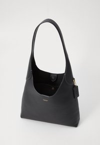 Black leather handbag with a rounded design, curved shoulder strap, and a gold logo accent. Features an open top and interior pocket.