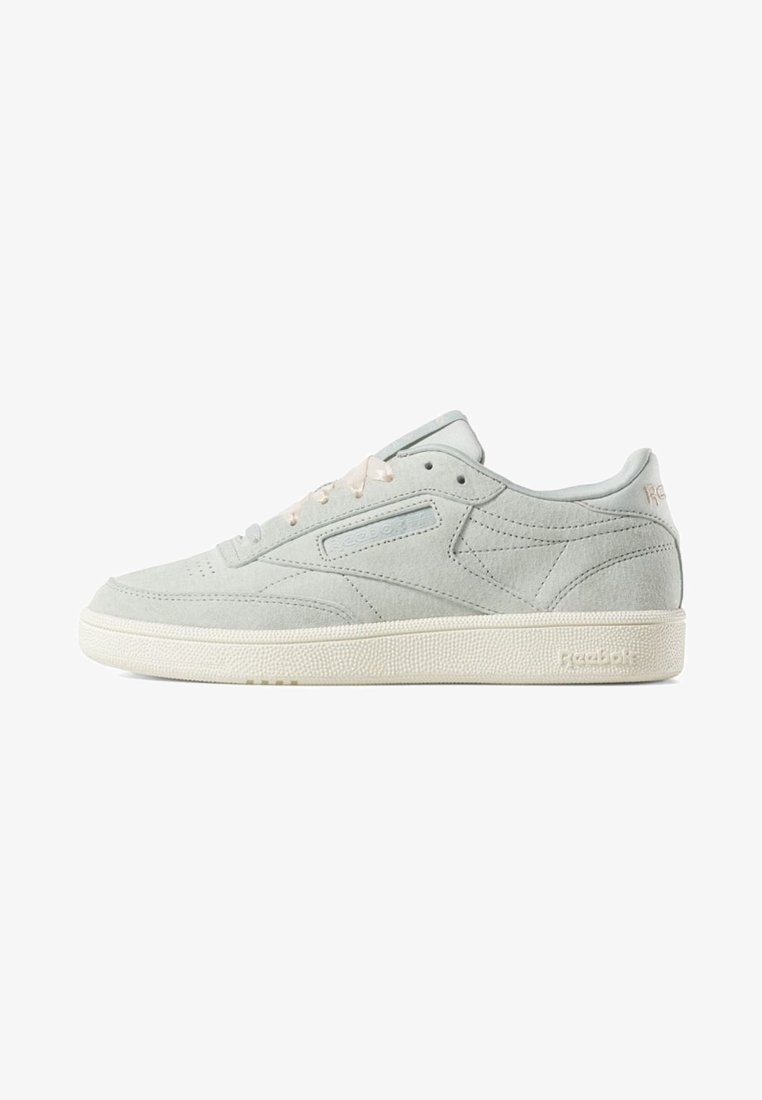 Baskets Reebok basses gris clair avec dessus en suède, lacets blancs et semelle en caoutchouc texturée écrue.