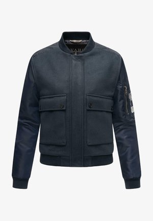 Jachetă de bombardier navy cu față din lână și mâneci din nylon, dotată cu două buzunare cu nasturi și un buzunar cu fermoar pe braț pentru un plus de utilitate.