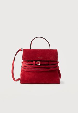 Sac à main en daim rouge avec poignée supérieure, bandoulière réglable, détail ceinture à l'avant et logo Moschino sur le rabat.