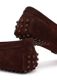 Mocassini in pelle scamosciata marrone scuro con grip in gomma a piccoli ciottoli sui talloni e sulle suole, progettati per un uso casual e una trazione migliorata.