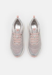 Szare i różowe sportowe tenisówki z teksturowaną materiałową cholewką, zaokrąglonym kształtem oraz gumową podeszwą z pętelką do ściągania i sznurowaniem.