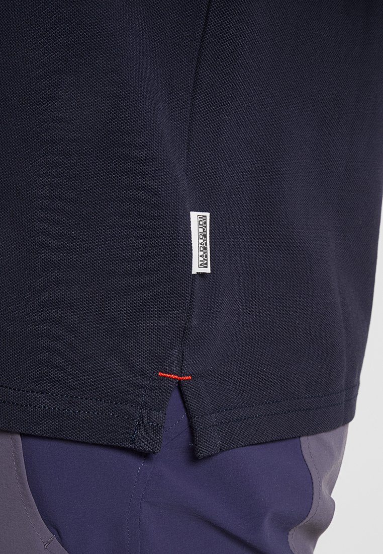 Granatowa koszula z krótkim rękawem o teksturowanej strukturze, z akcentami wentylacyjnymi po bokach i kontrastowym czerwonym przeszyciem. Posiada metkę z logo "NAPAPIJRI".