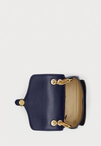 Borsa in pelle blu con manici in catena dorata, un esterno strutturato e una chiusura a bottone. L'interno è beige senza scomparti aggiuntivi.