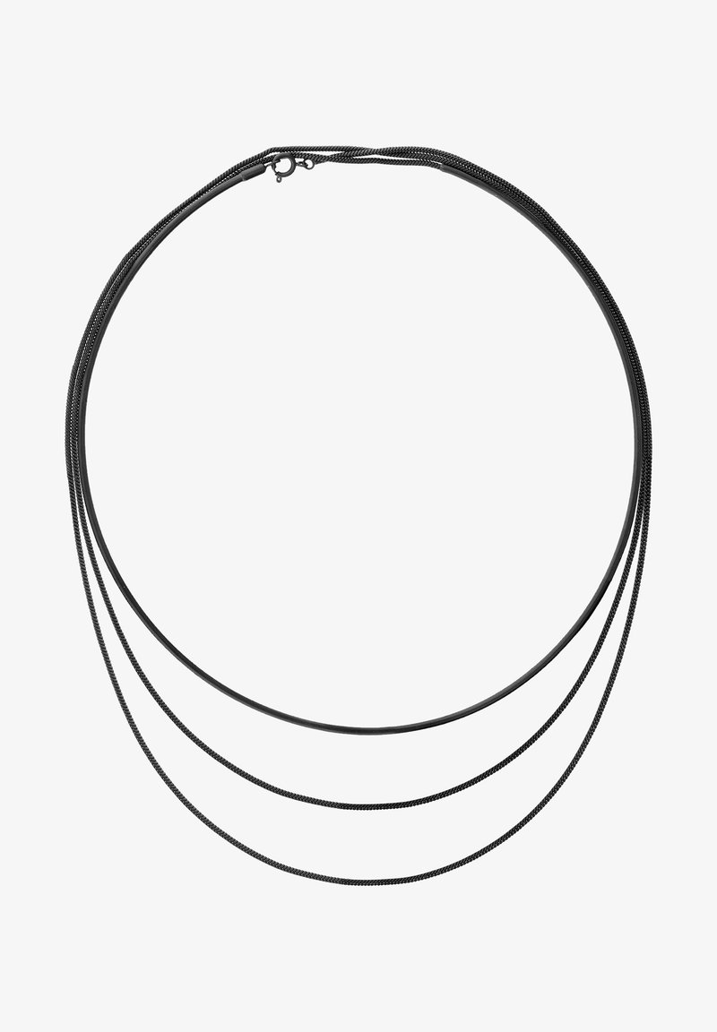 Trois fines chaînes en métal noir reliées par un fermoir circulaire, disposées en boucles décroissantes sur un fond blanc.