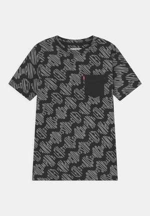 T-shirt noir à manches courtes avec un motif de texte stylisé gris couvrant l'ensemble et une poche poitrine noire unie avec une petite étiquette rouge.