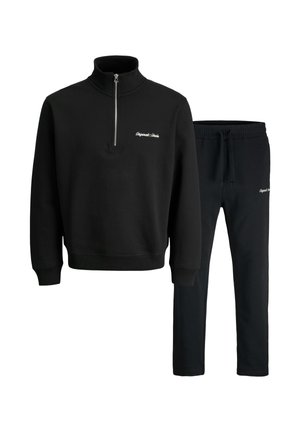 Schwarzer Sweatshirt mit einem Reißverschlusskragen und passenden schwarzen Jogginghosen. Beide aus einem weichen, strukturierten Stoff mit gesticktem Logo gefertigt.