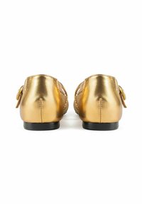 Metalen gouden schoenen met een gladde textuur en een lage zwarte hak. Heeft een geweven ontwerp aan de voorkant en decoratieve gesp-accenten aan de zijkanten.