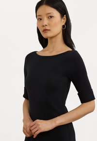 Black fitted dress with a boat neckline, three-quarter length sleeves, and a smooth texture. No visible patterns or embellishments.