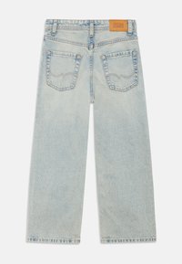 Light blue denim wide-leg jeans with a mid-rise waist, two back pockets, and stitched brand label at the back waistband.