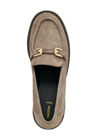 Mocasines de ante marrón con un diseño acolchado y acentos de hardware en tono dorado. Suela texturizada y plantilla acolchada para mayor comodidad.