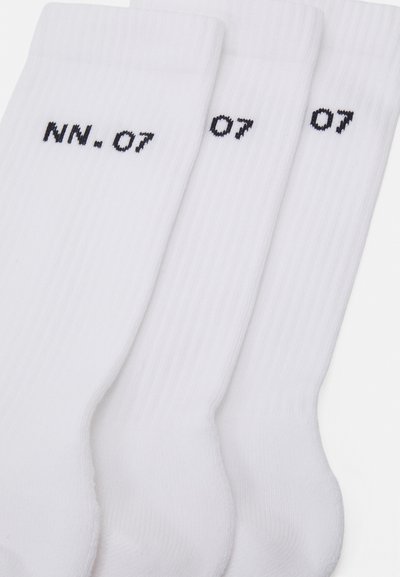 Calcetines de algodón blancos con textura acanalada, que presentan texto bordado en negro "NN. 07" y el número "07" cerca de la parte superior. Conjunto de tres pares.
