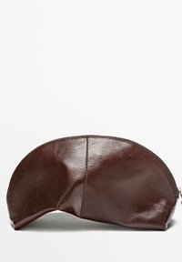 Pochette en cuir marron avec un dessus arrondi, une fermeture éclair et une texture lisse. Présente une couture cousue le long du côté. Base plate pour la stabilité.