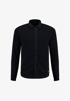 Granatowa kurtka na guziki z teksturowanej tkaniny, z kołnierzem, długimi rękawami i dwoma przednimi kieszeniami. Podkreślona ciemnymi guzikami.