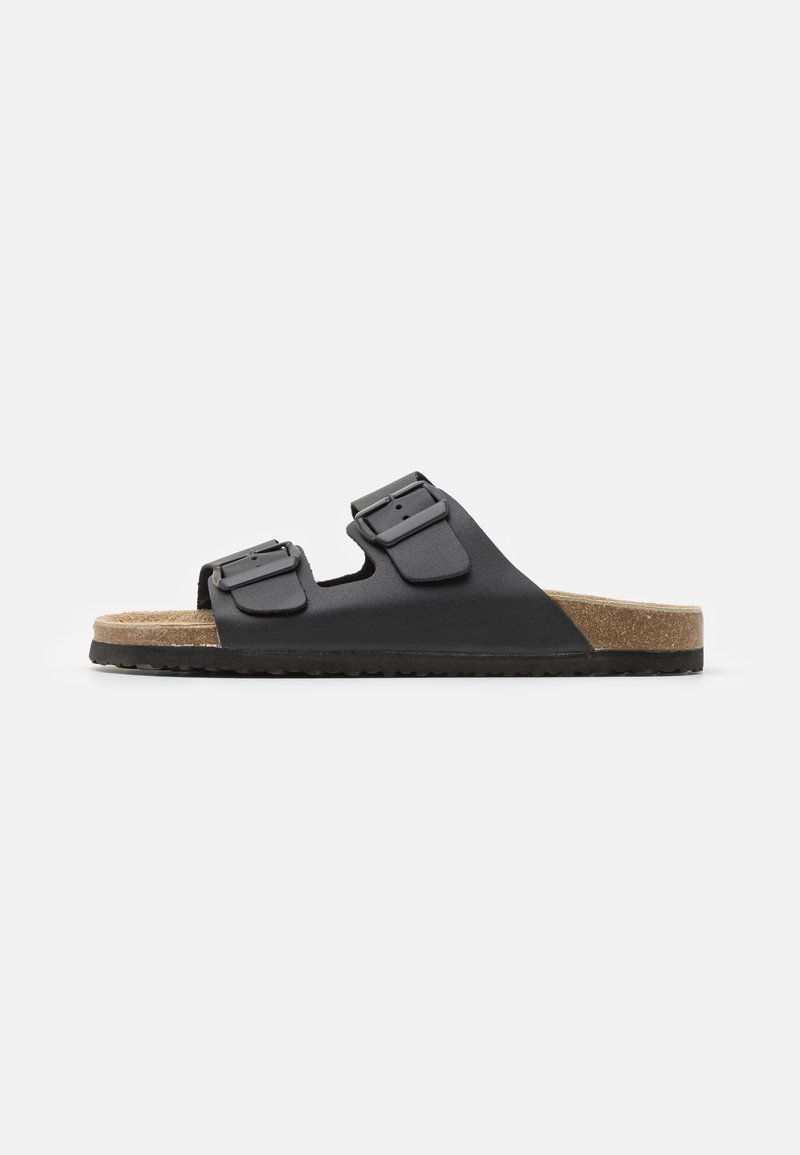 Black slide sandal with two adjustable buckles, textured footbed, and cork-like sole. Features a flat, wide design for comfort.