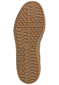 Rubber sole with a textured pattern, featuring wavy lines and angular shapes. "adidas" logo embossed on the side. Tan color.