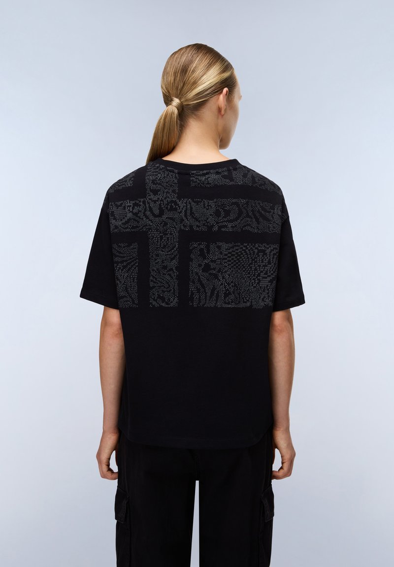 Černé bavlněné tričko s texturovaným grafickým designem v šedé na zadní straně. Kulatý výstřih, krátké rukávy a volný střih.
