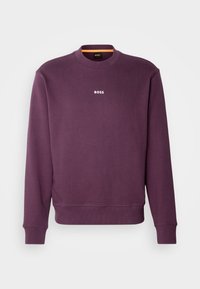 Fialová mikina z bavlněné směsi s žebrovanými manžetami a lemem. Na hrudi má bílý nápis "BOSS". Klasický střih s kulatým výstřihem.