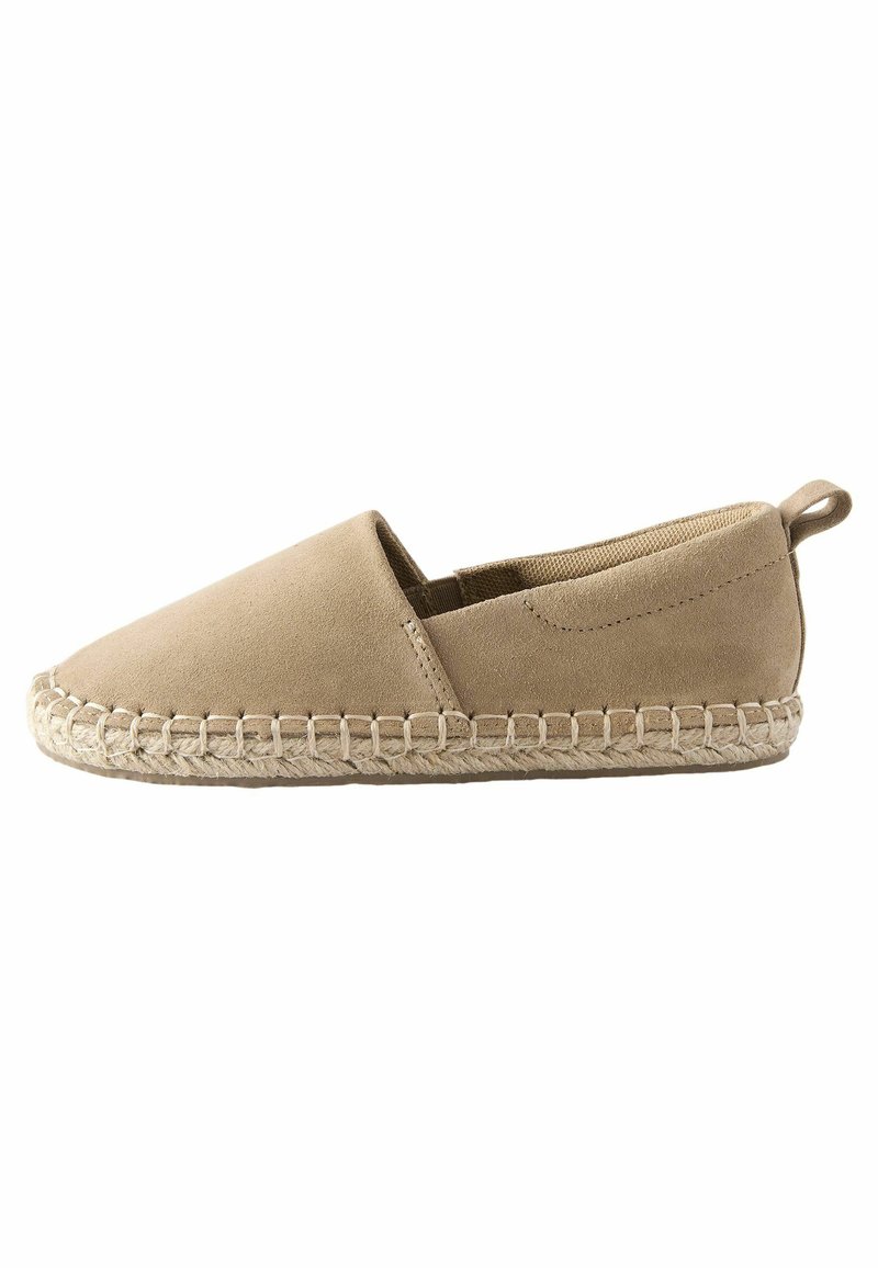 Espadrilles de ante beige con puntera redondeada, paneles laterales elásticos y suela de yute trenzado. Detalle de costura a lo largo de los bordes.