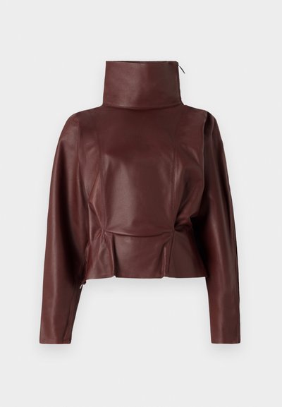 Burgundy leather cropped jacket with a high collar, structured shoulders, and side zipper detailing. Smooth texture and tailored seams.