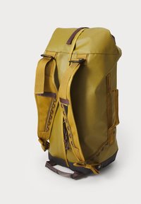 Gelber Rucksack mit verstellbaren Trägern, glattem synthetischem Material, kontrastierender dunkler Basis, Seitentaschen und dekorativen Nähten.