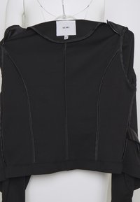 Mustat yläosat, joissa on rakenteellinen muotoilu, sileä rakenne ja näyttävät ompeluyksityiskohdat. Ompelussa on merkki "ICHI" kauluksessa.