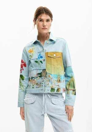 Světlá modrá džínová bunda s květinovou výšivkou a potiskem městské scenérie, se žlutou náprsní kapsou a kovovými knoflíky. Texturovaná tkanina.