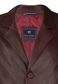 Brun læderjakke med en notch-krave, knaplukning og en maroon foring. Mærket læser "FELIX HARDY" med en størrelse tag.