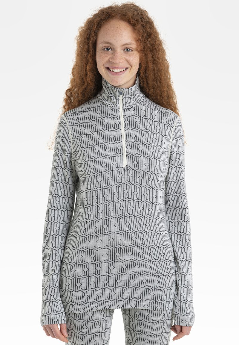 Hellgrauer Reißverschluss-Pullover mit einem sich wiederholenden schwarzen Muster, langen Ärmeln mit Daumenlöchern und einem hohen Kragen.