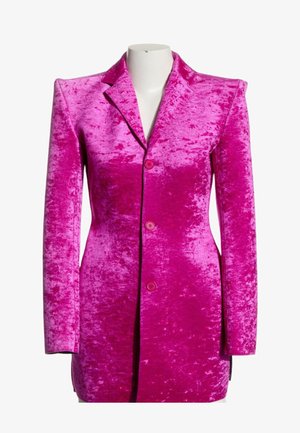 Blazer de terciopelo aplastado de color rosa brillante con mangas largas, cuello con solapa entallada y tres botones delanteros sobre un torso de maniquí blanco.