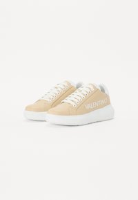 Beige sneakers med hvite snører, teksturert læroverdel, merket "VALENTINO" på siden, og en kraftig hvit gummisåle.