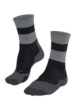 Calze atletiche nere con strisce grigie e punta rinforzata. Realizzate in materiale sintetico, progettate per comfort e durata. Parte superiore a maglia piatta.