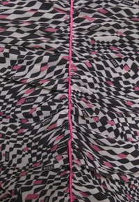 Un tessuto a fantasia nero, bianco e rosa presenta un design a zigzag con una texture arricciata, accentuato da un dettaglio di cucitura rosa.