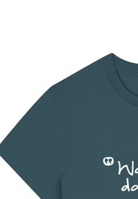 Teal katoenen t-shirt met korte mouwen en een ronde halslijn, voorzien van witte bedrukte tekst en aanhalingstekens op de voorkant.