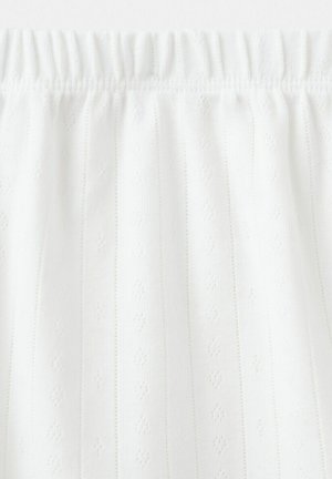 Tissu blanc à motifs subtils de rayures verticales et d'œillets en forme de losange, froncé à une taille élastique.