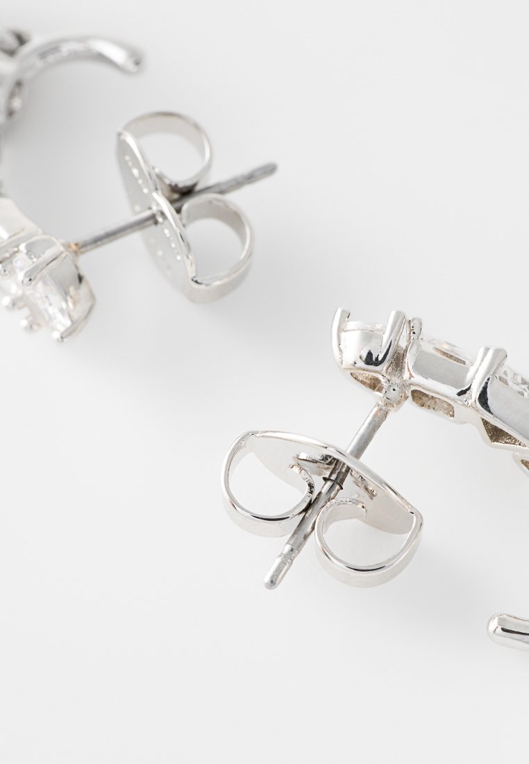 Silberne Metallohrringe mit geometrischem Design, polierter Oberfläche und einfacher Stecker-Verschluss. Reflektierendes und elegantes Aussehen.