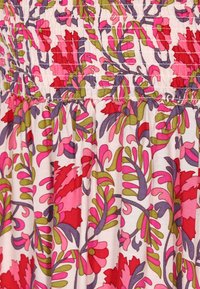 Blumenmusterstoff mit großen rosa und roten Blumen sowie grünen Blättern auf einem hellen Hintergrund. Raffinierte Struktur mit elastischen Details.