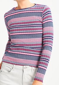 Haut à manches longues rayé en bleu marine, rose et blanc. Présente un motif en maille texturée avec des lignes horizontales et un col rond.