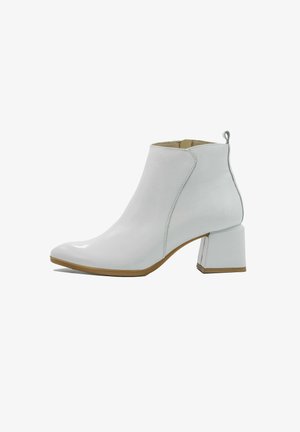 White leather ankle boots with a block heel, pointed toe, side stitching details, and a small pull tab at the back.